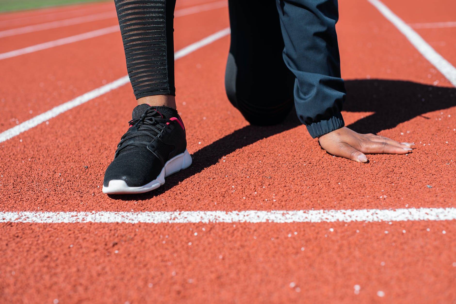 person in black pants and black and white nike sneakers