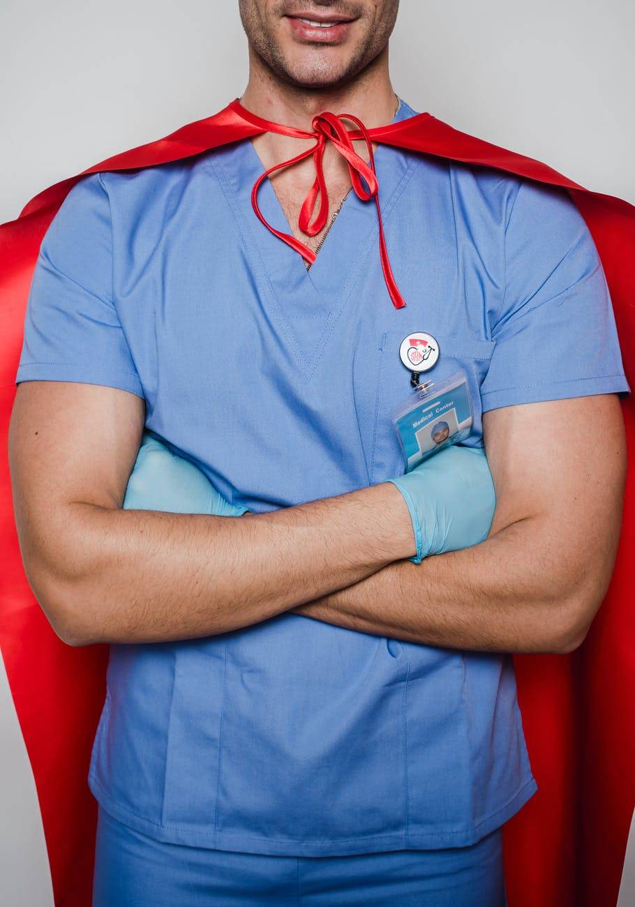 smiling doctor in uniform and superhero costume