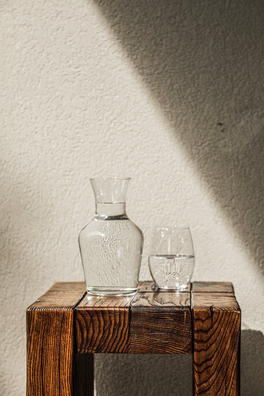 glass pitcher and drinking glass on wooden table